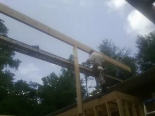 Carpenter setting a ridge beam over a new addition frame — Ice Dam Removal by Roofing Brothers in Big Bear Lake