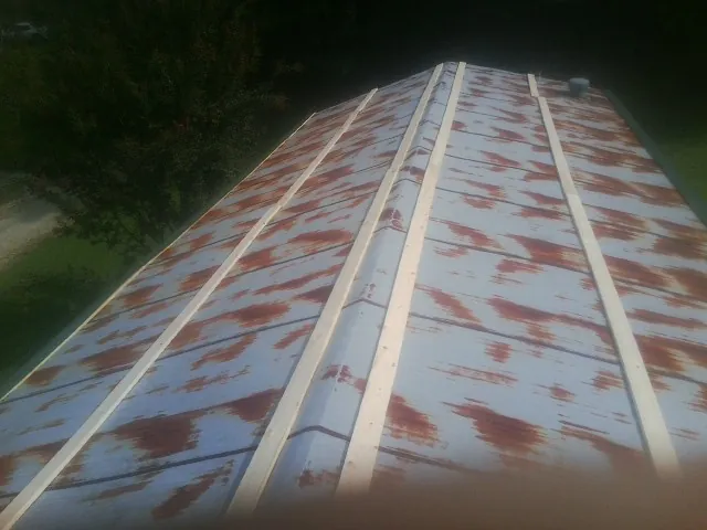 Rusted metal roof panels with new wood purlins before replacement — Storm Damage Roof Repair in Big Bear Lake by Roofing Brothers