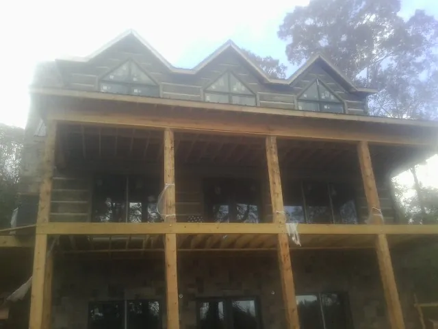 Dormers and porch framing on a large log home under construction — Roof Coating work by our crew in Big Bear Lake