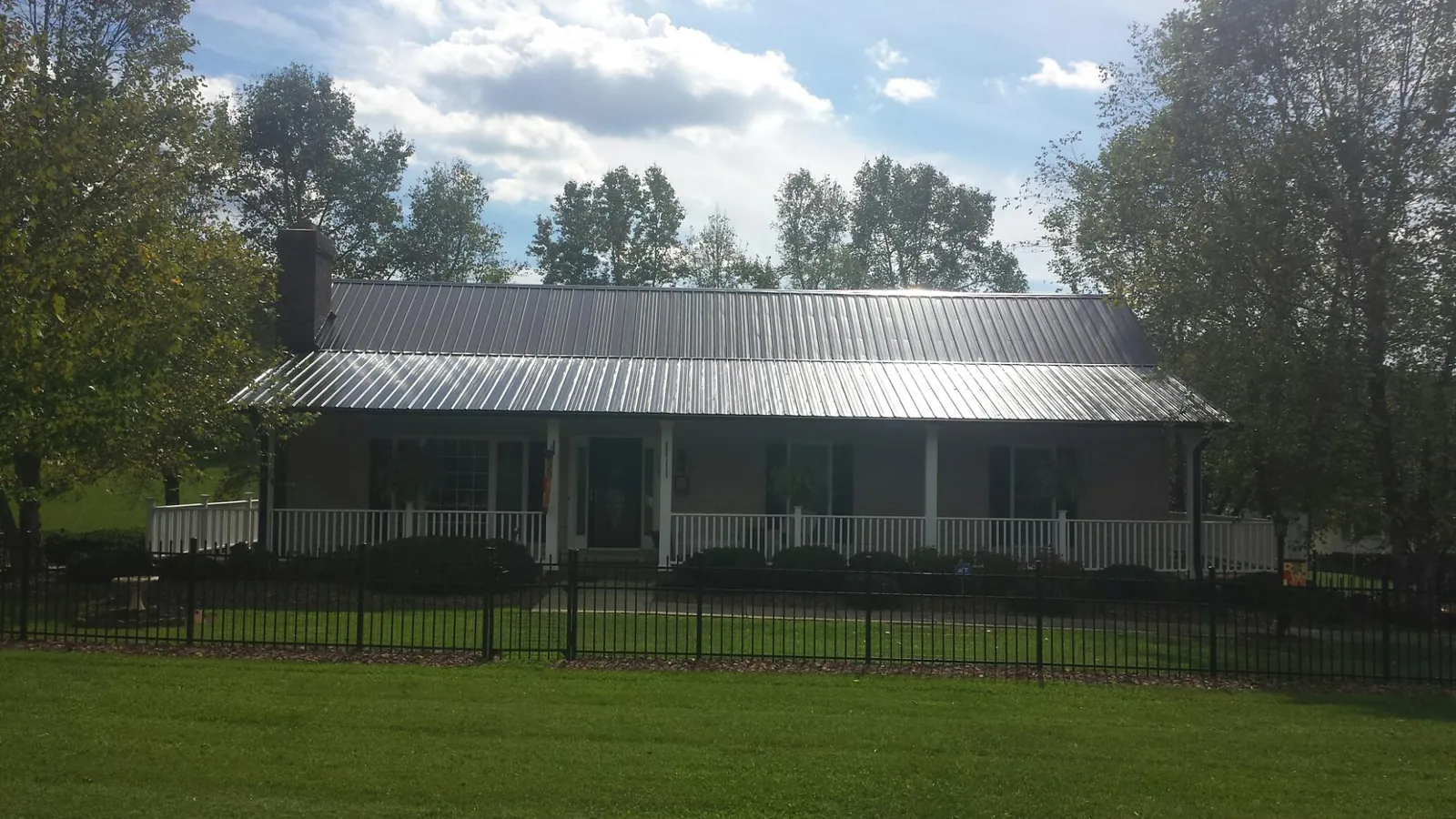 Gray metal roof on a brick ranch with a full width front porch — Gutter Guard Installation work by our crew in Big Bear Lake