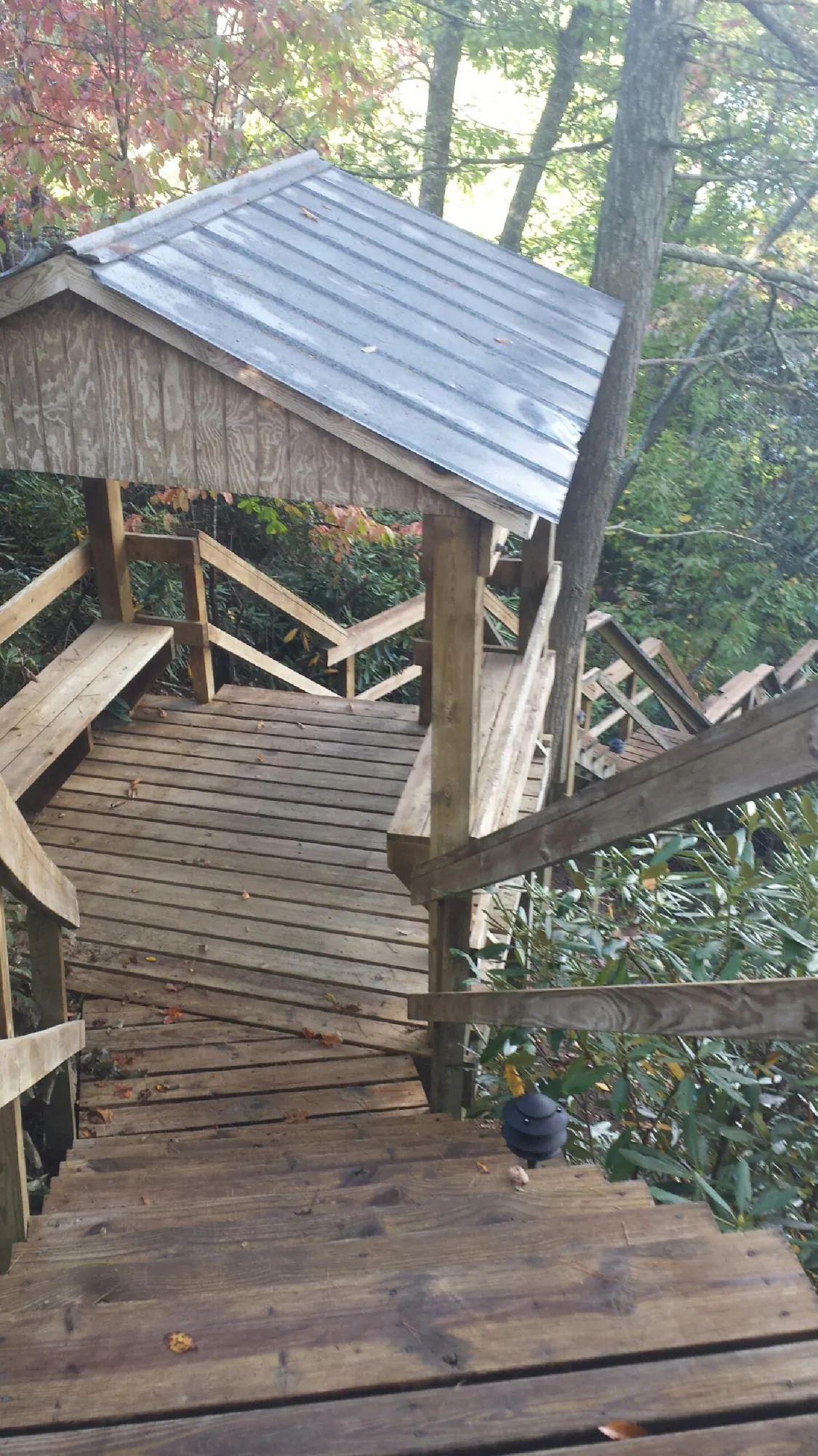Metal roofed shelter over wooden steps on a wooded walkway — Skylight Repair & Installation work by our crew in Big Bear Lake